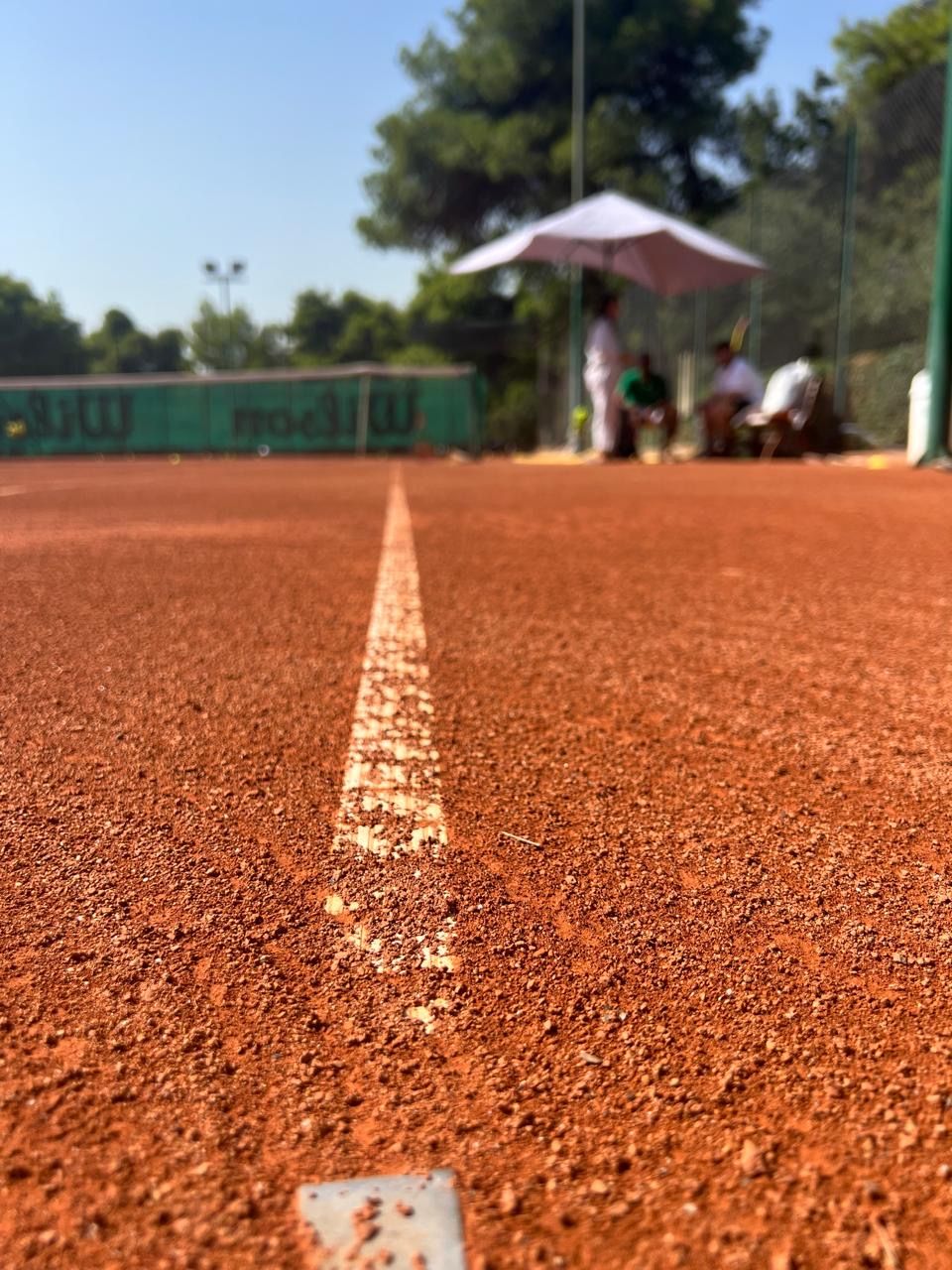 Close-up of the baseline chalk on red clay