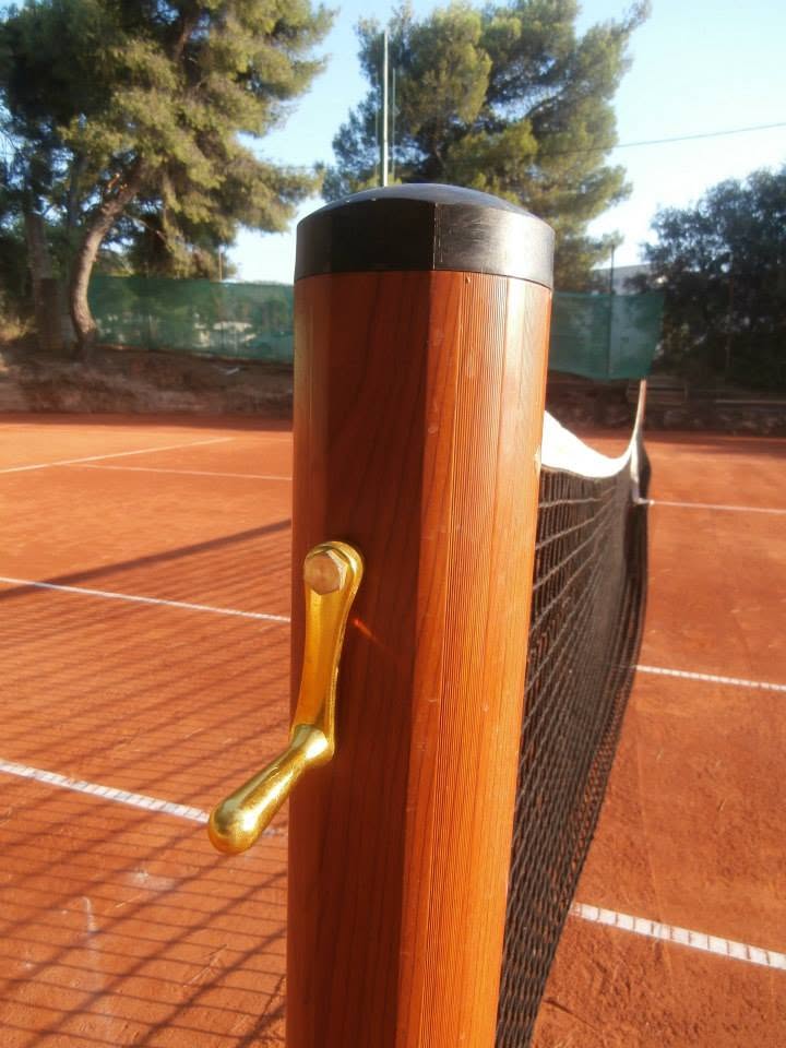 Wooden net-post detail, brass tightener, low sun on the clay