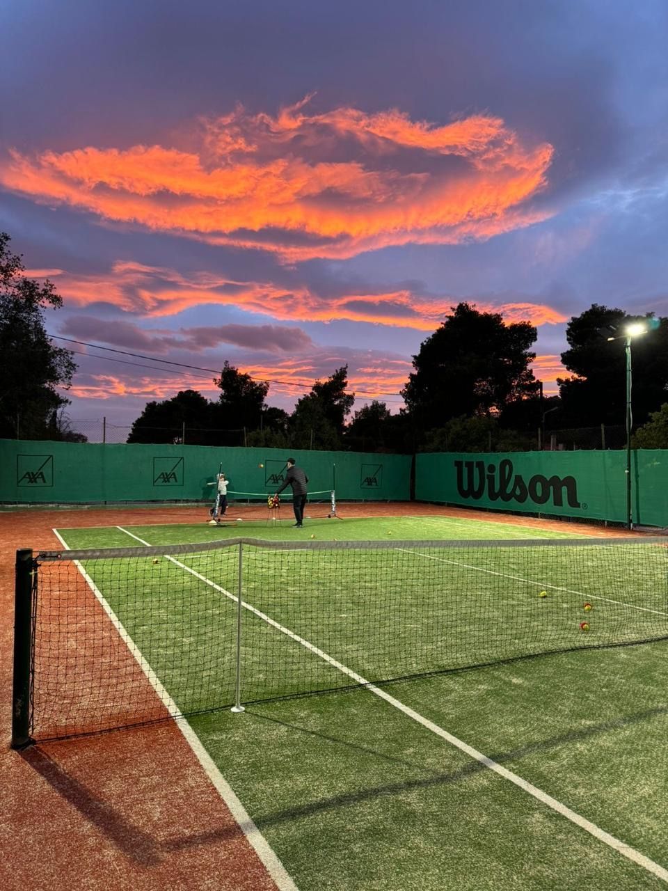 Sunset lesson on the turf court, orange clouds above